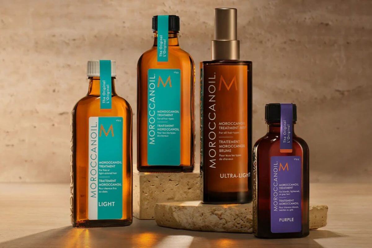 Nashville Steals, Deals & Announcements: June 2026 - 6 Four bottles of Moroccanoil hair treatment products are displayed on beige stone blocks against a neutral background.