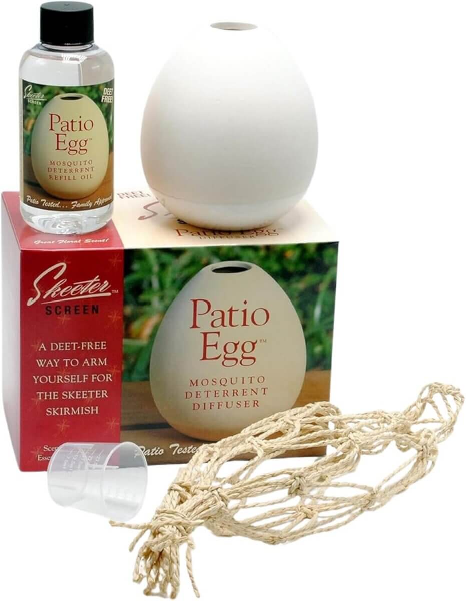 A Patio Egg mosquito deterrent diffuser set—an outdoor must-have for entertaining essentials—includes a white egg-shaped diffuser, refill oil bottle, rope net, measuring cup, and product packaging box.