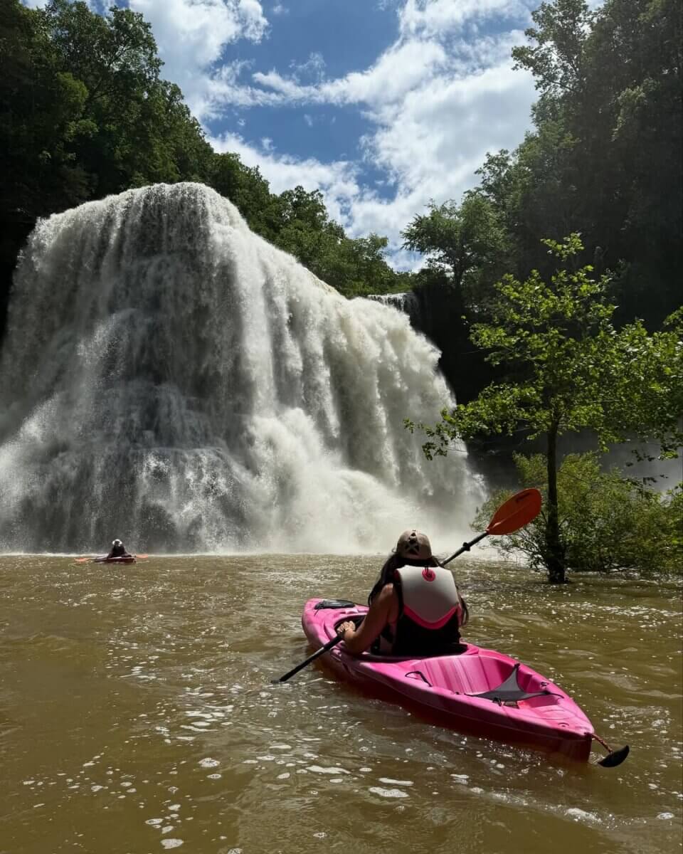 Epic Kayak Adventures in the South - 11 Embark on epic Kayak Adventures as a person in a pink kayak paddles towards Burgess Falls in Tennessee.
