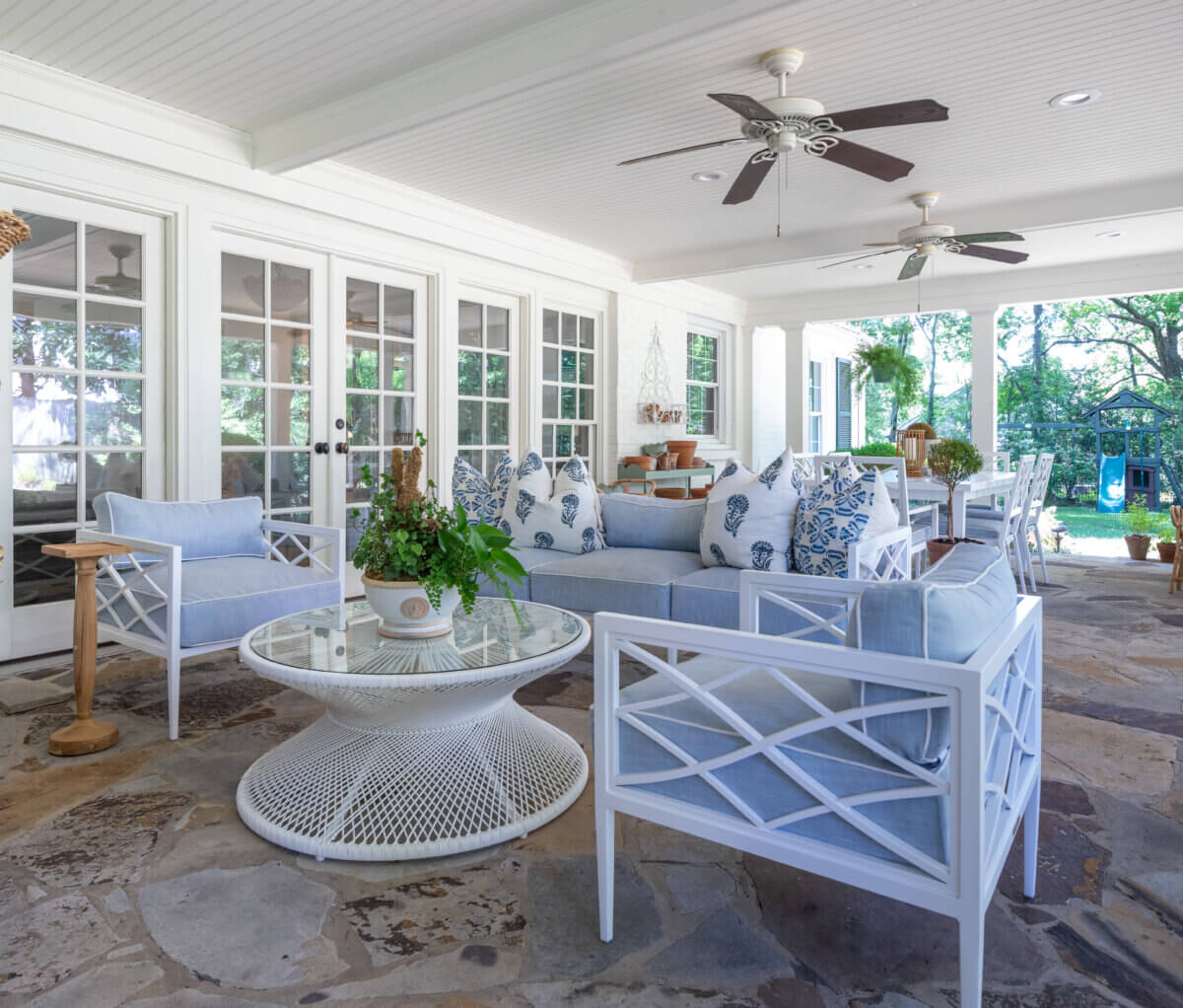 10 Designer Tips for Upgrading Your Outdoor Spaces - 4 A patio with blue couches and fans.