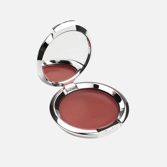 Open compact case with a reddish-brown cream makeup and a round mirror inside the lid, perfect for quick summer makeup tips, set against a plain white background.