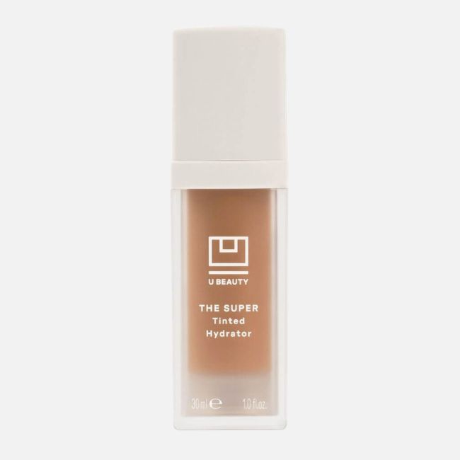 A bottle of U Beauty The Super Tinted Hydrator with a white cap and clear container displaying the tinted product inside—an ideal pick for effortless, glowing skin in your summer makeup tips routine.
