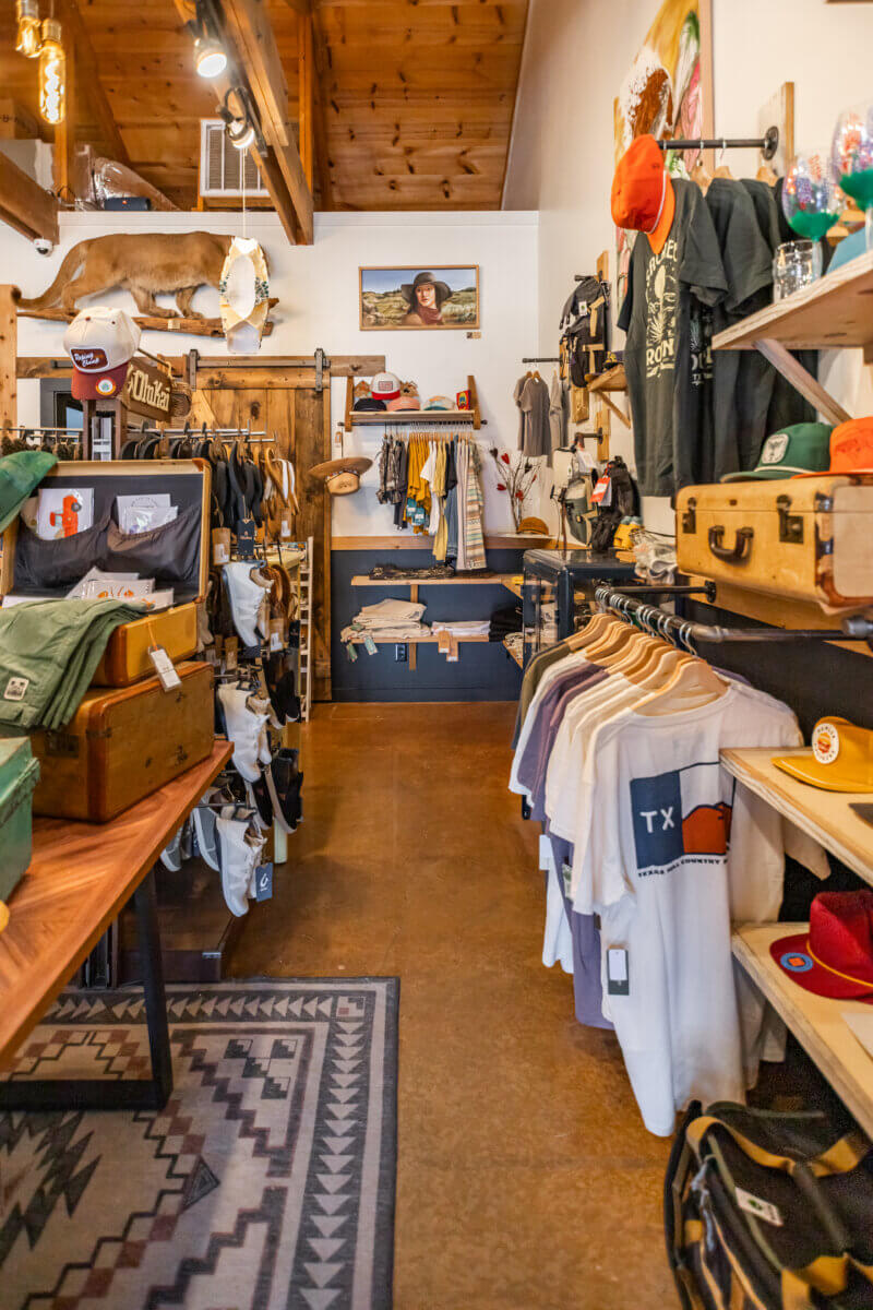 How to Eat, Shop & Play Your Way Through Texas - 5 The interior of a store displays vintage finds, including clothing, hats, and suitcases.