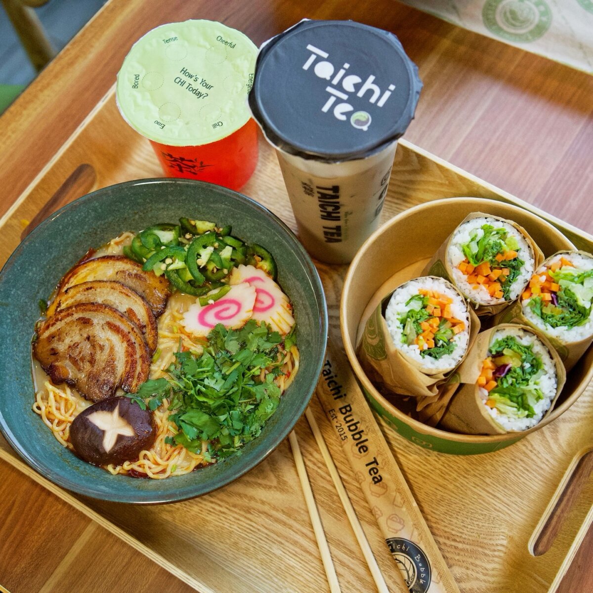 7 New Nashville Restaurants to Try This Month - 6 A bowl of ramen with sliced pork, vegetables, and mushrooms, four vegetable sushi rolls, and two bubble tea drinks on a tray.
