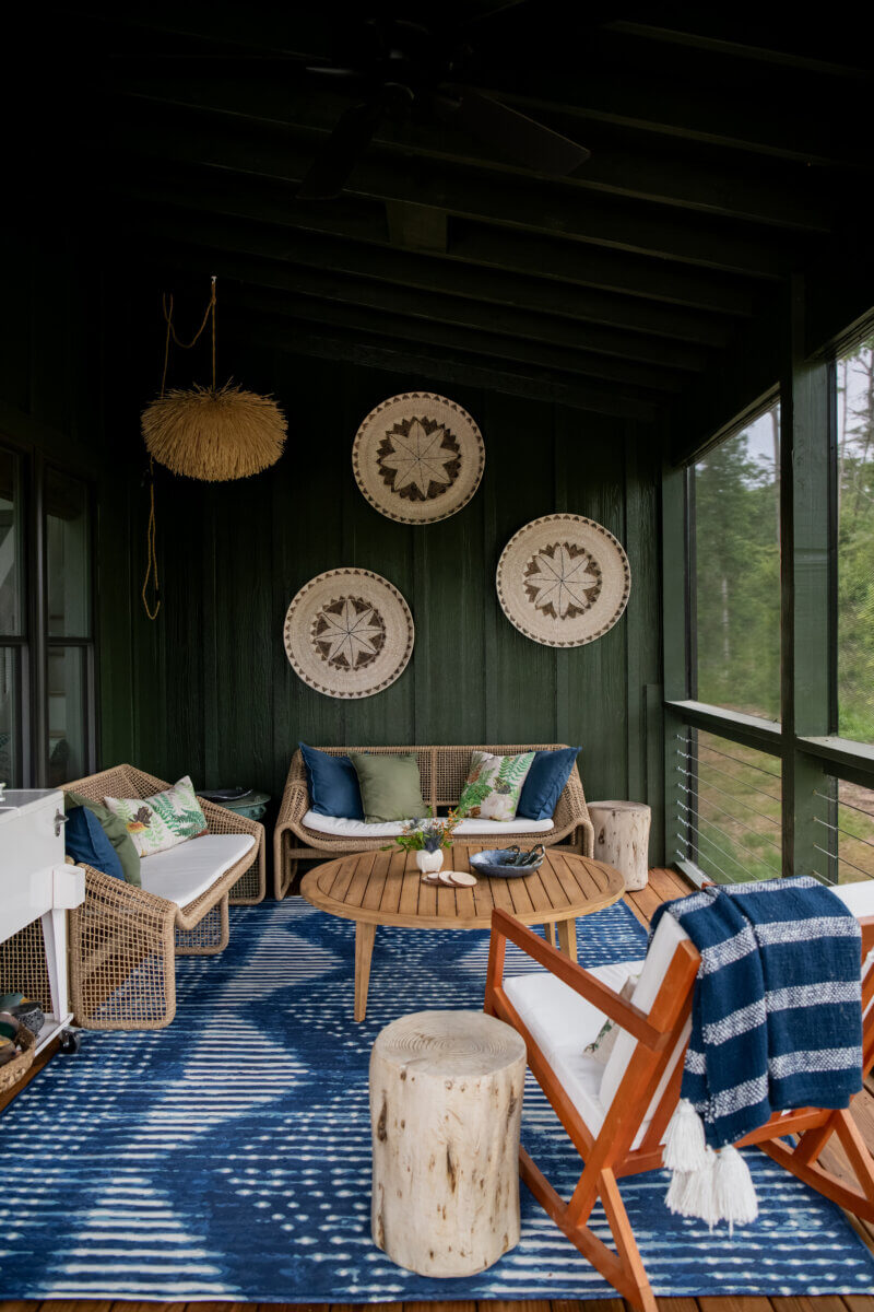 10 Designer Tips for Upgrading Your Outdoor Spaces - 5 A screened-in porch with a blue area rug and chairs.