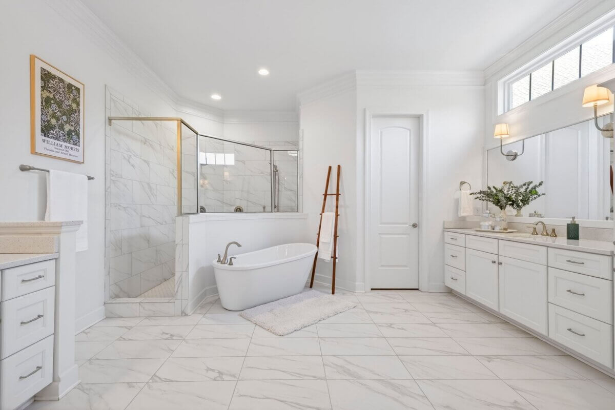 Spacious bathroom in Franklin TN real estate featuring white cabinets, a freestanding bathtub, glass-enclosed shower, double sink vanity, and tile flooring at 2708 Eglington Terrace.