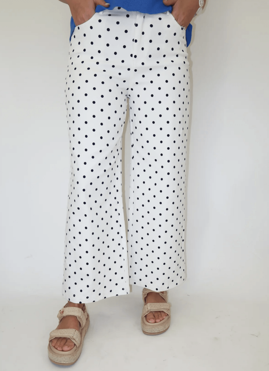22 Birmingham FINDS for June: Breezy Dresses, Entertaining & Gifts for Dad - 2 Person wearing white wide-leg pants with black polka dots, a blue top, and beige sandals, standing against a plain background.