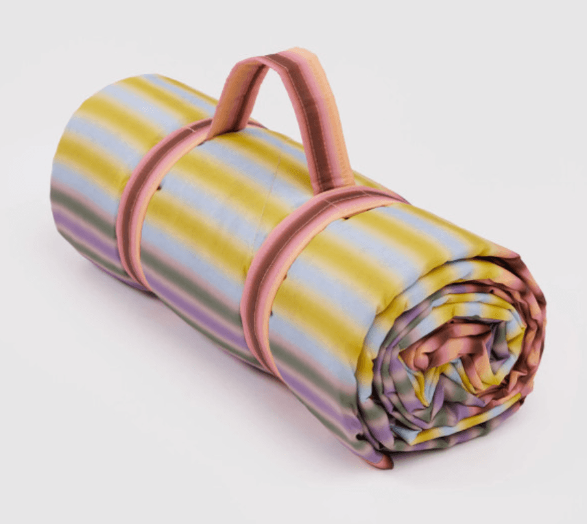 22 Birmingham FINDS for June: Breezy Dresses, Entertaining & Gifts for Dad - 13 A rolled-up blanket with pastel yellow, blue, and pink stripes, secured with pink straps and a matching handle—perfect for your June FINDS in Birmingham.