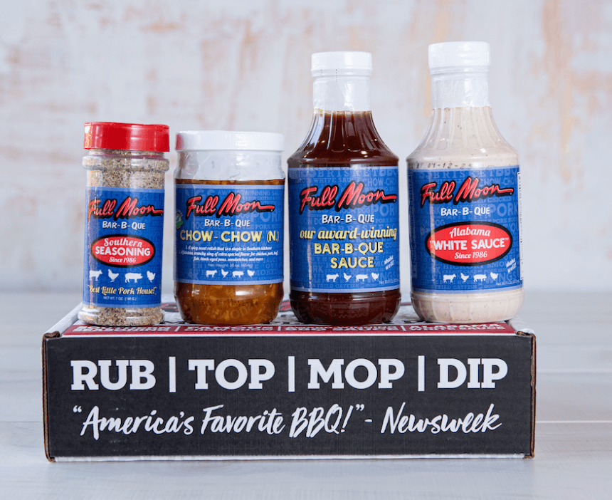 22 Birmingham FINDS for June: Breezy Dresses, Entertaining & Gifts for Dad - 23 Four Full Moon Bar-B-Que products—seasoning, chow-chow, bar-b-que sauce, and white sauce—are displayed on a branded box with a Newsweek quote, highlighting these Birmingham FINDS perfect for June gatherings.