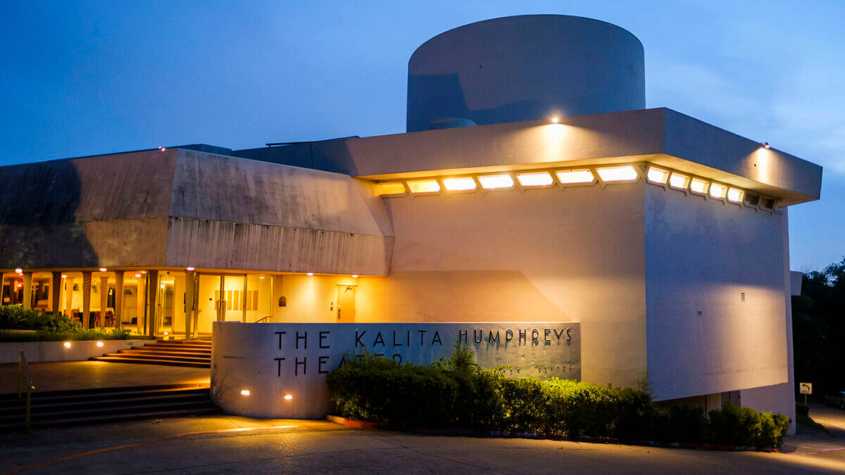 The Kalita Humphreys Theater, a rare Frank Lloyd Wright design in the South, stands at dusk, illuminated by exterior lights that highlight its modern architectural features and distinctive signage.