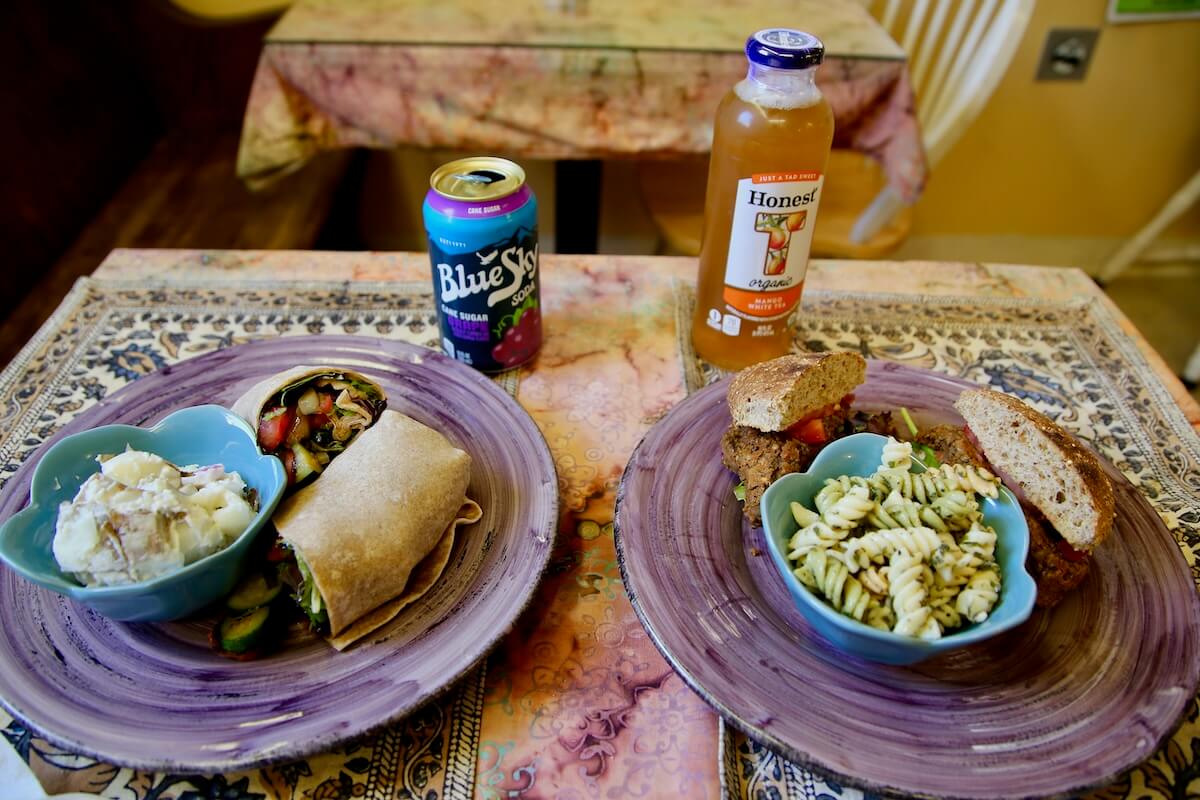 Where to Eat & Sip in Gatlinburg: From Local Favorites to Hidden Gems - 5 Two plates on a patterned tablecloth, each with a sandwich, a side of pasta or potato salad, and drinks — a Blue Sky soda and an Honest Tea bottle — showcasing flavors perfect for your Gatlinburg dining guide.