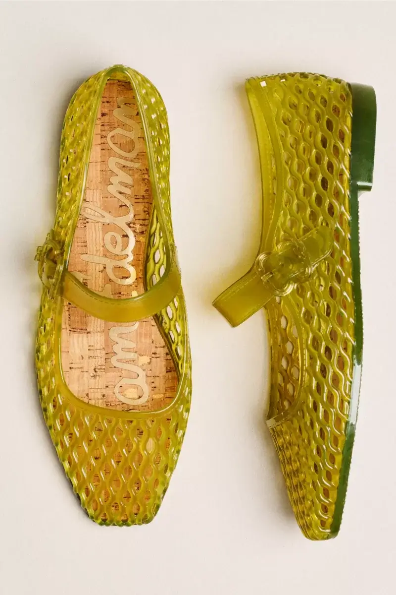 A pair of translucent yellow-green plastic Mary Jane shoes with a perforated design and cork insoles, featured on the SB Hot List for July 2026, displayed on a neutral background.