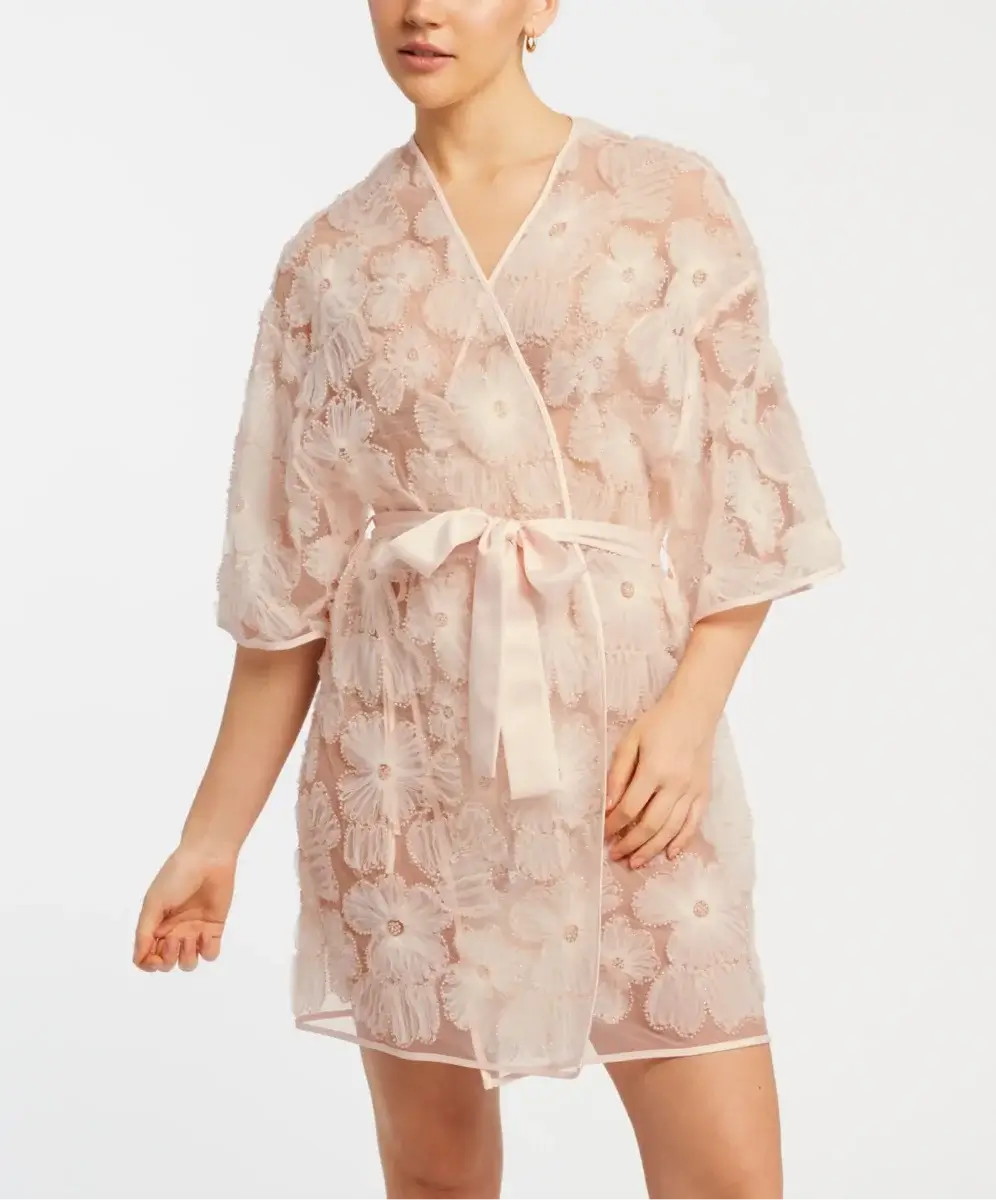 16 Luxe Louisville FINDS for July: Fine Art, Rare Bourbon & Resort-Ready Style - 9 A woman wearing a sheer, knee-length robe with a floral embroidered pattern and matching belt stands against a plain white background.