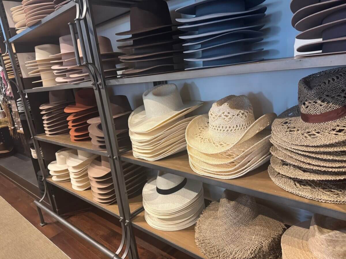 16 Louisville FINDS for June: Summer Style, Tabletop Charm & Little Luxuries - 6 Shelves display stacks of cowboy hats in various shades and materials, including felt and straw—perfect summer picks for those seeking everyday luxuries—in a neatly arranged Louisville store.