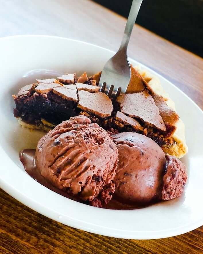 10 Louisville Ice Cream Spots to Beat the Heat - 8 A slice of chocolate pie with a fork and two scoops of Louisville ice cream served on a white plate.