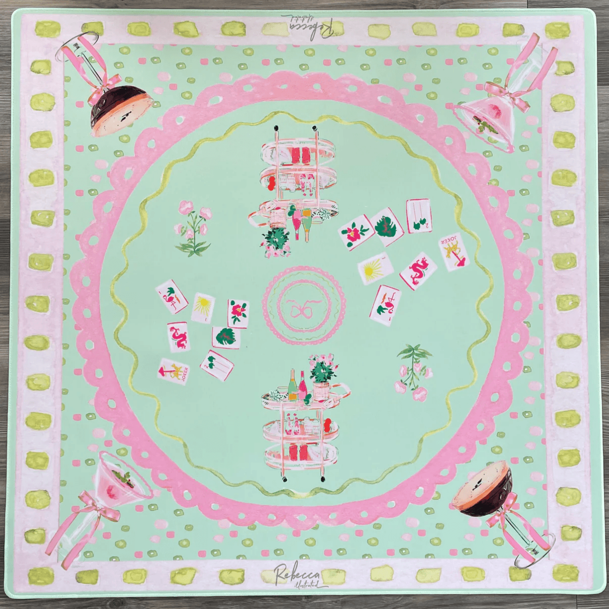 Your Ultimate Louisville Mahjong Guide - 6 A square pastel-colored scarf featuring tea stands, cards, flowers, and cocktails arranged symmetrically on a mint green background with pink and yellow decorative borders.