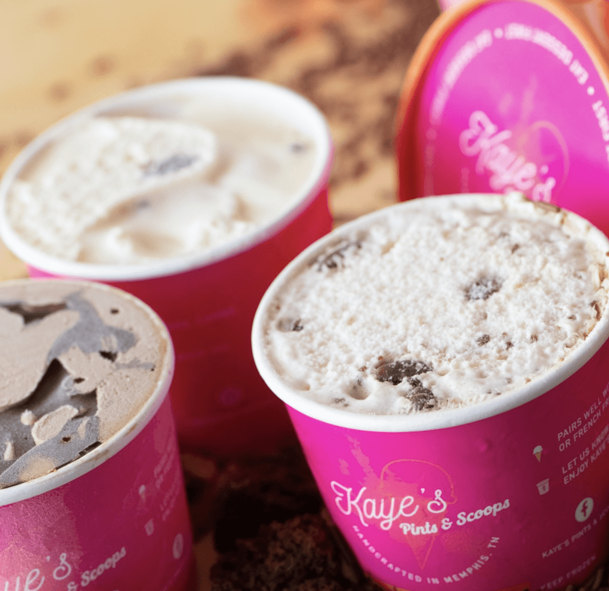 Three opened pints of ice cream in pink Kaye's Pints & Scoops containers are arranged closely together on a table.
