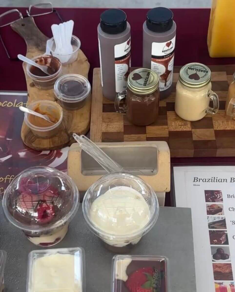 Your Updated Guide to South Main: A Hot Spot with Rich History - 7 A display of desserts in plastic cups and jars, alongside bottles of chocolate drinks and a menu on a table.