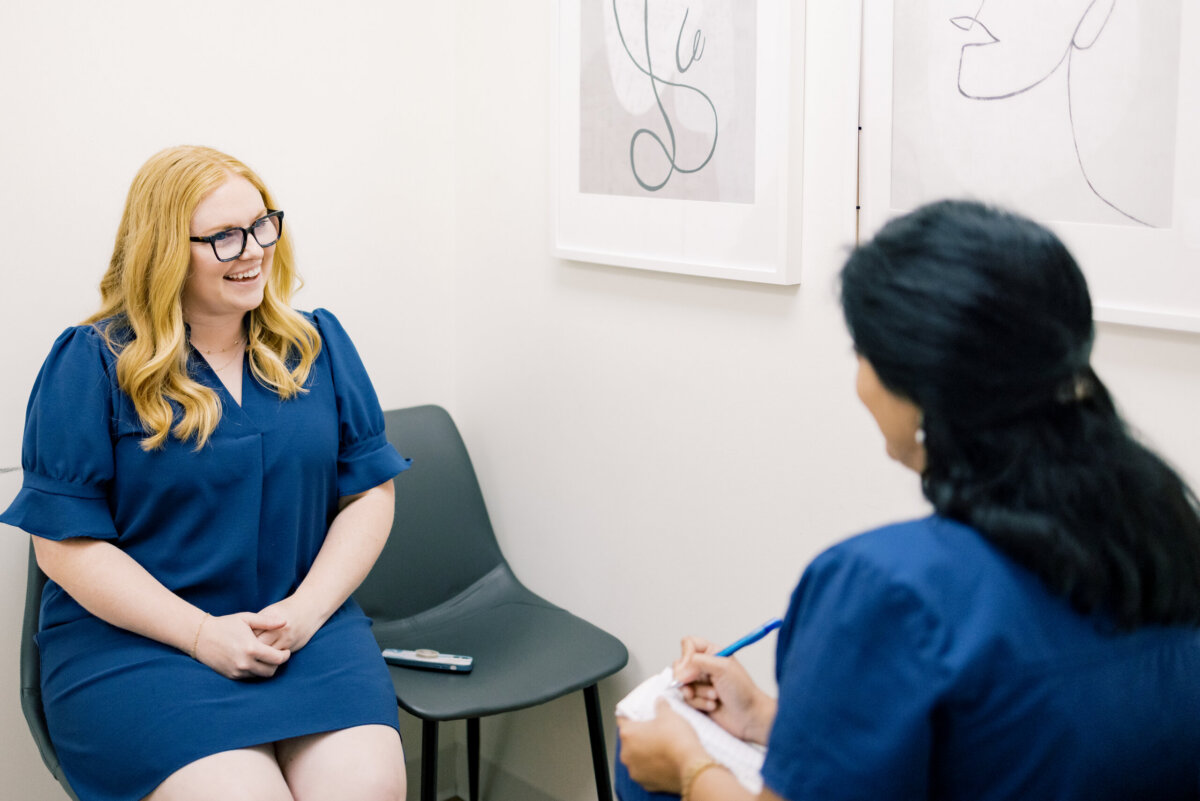 Beyond Birth: Why Women Are Choosing Midwives for Everyday Care - 4 Two women in blue discuss pregnancy in a clinical setting.
