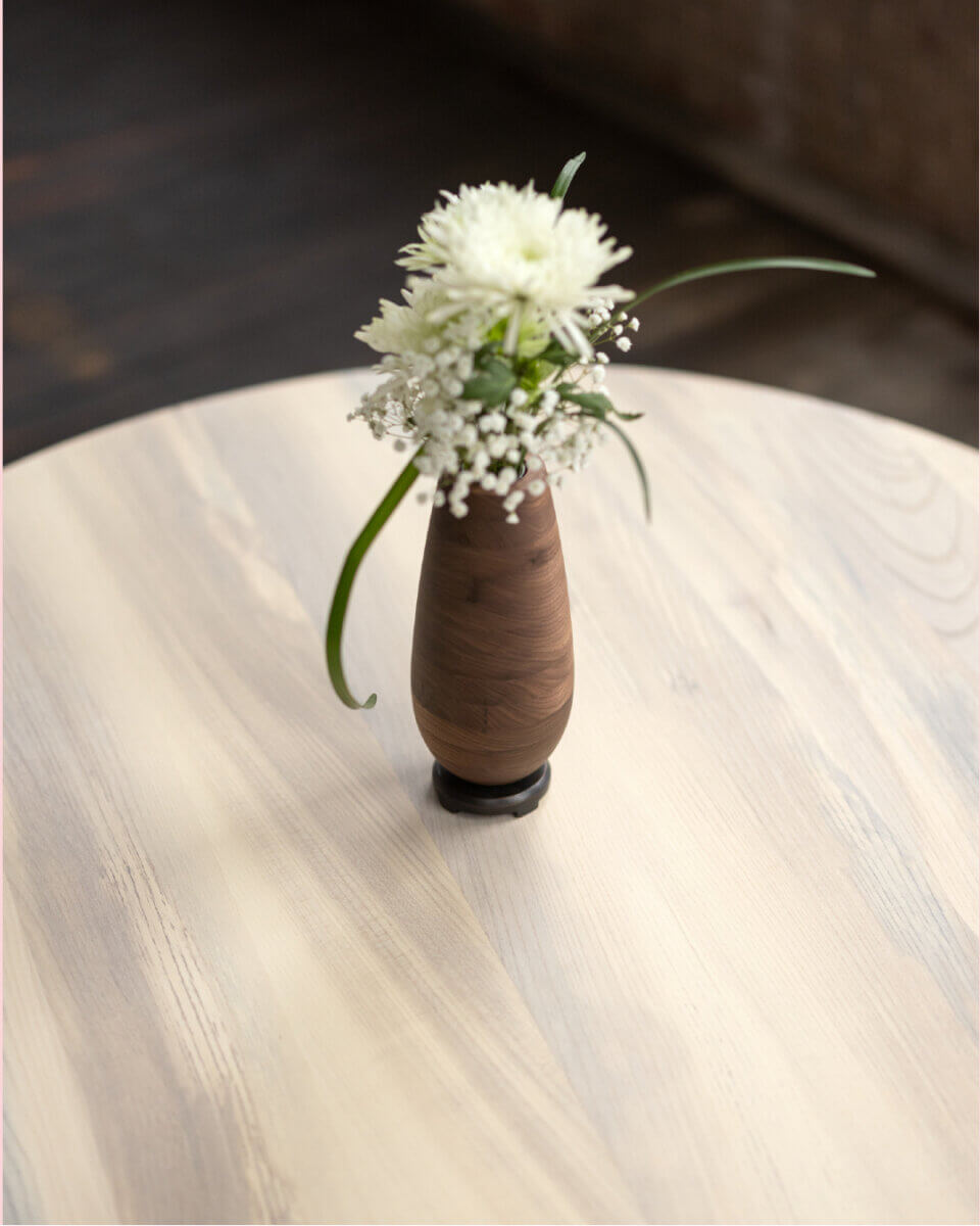Turning Fallen Trees into Fine Furniture: The Art of Alabama Sawyer - 7 A small wooden vase with white flowers sits on a light-colored wooden table.