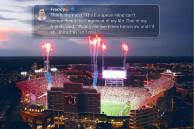 Aerial view of a packed football stadium at night with red fireworks above; a tweet overlay expresses disbelief at the World Cup spectacle.