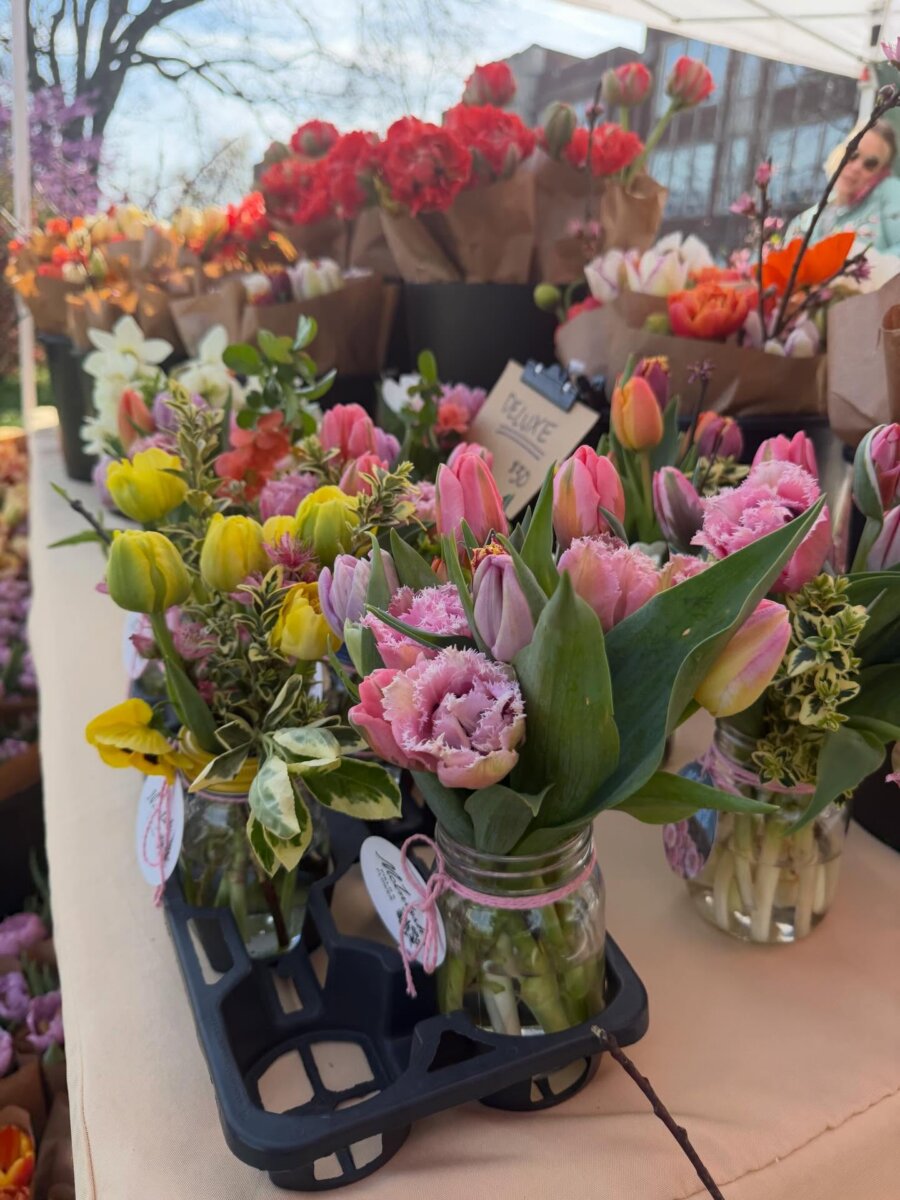 Your Guide to Sylvan Park: Nashville's Coziest Neighborhood - 8 Various bouquets of colorful tulips and flowers in glass jars are displayed on a table at a charming outdoor market stand in Sylvan Park, Nashville.