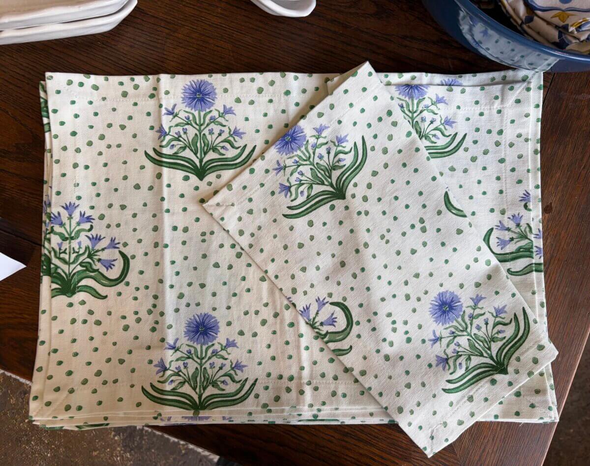15 Birmingham FINDS for August: Breezy Fashion, Entertaining & More - 12 Two white cloth napkins with green polka dots and purple flower designs are laid out on a wooden surface, perfect for adding a touch of charm to your table. These local finds, discovered in Birmingham this August, bring a fresh and cheerful vibe to any gathering.