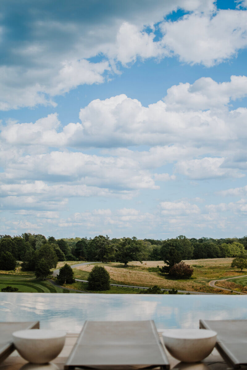8 Luxurious, Family-Friendly Resorts in the South - 12 A scenic view of a rural landscape with green fields, scattered trees, and a winding road under a partly cloudy sky—perfect for southern families seeking nearby family-friendly resorts.