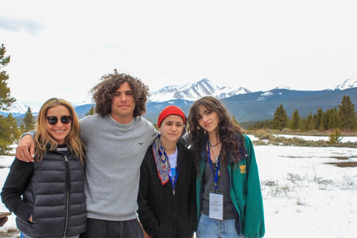 From Clinical Psychology to Cocktail Culture: Meet Heather Zamanian - 5 Four people stand together outdoors in front of snow-covered mountains and trees, dressed in casual winter clothing, smiling at the camera, drawing inspiration from the scenic landscape.
