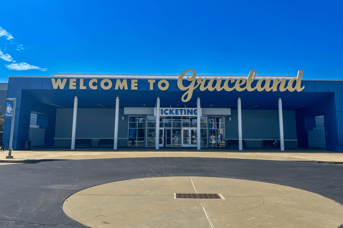 Entrance to the Graceland ticketing building with large "Welcome to Graceland" sign above the doors on a clear, sunny day.