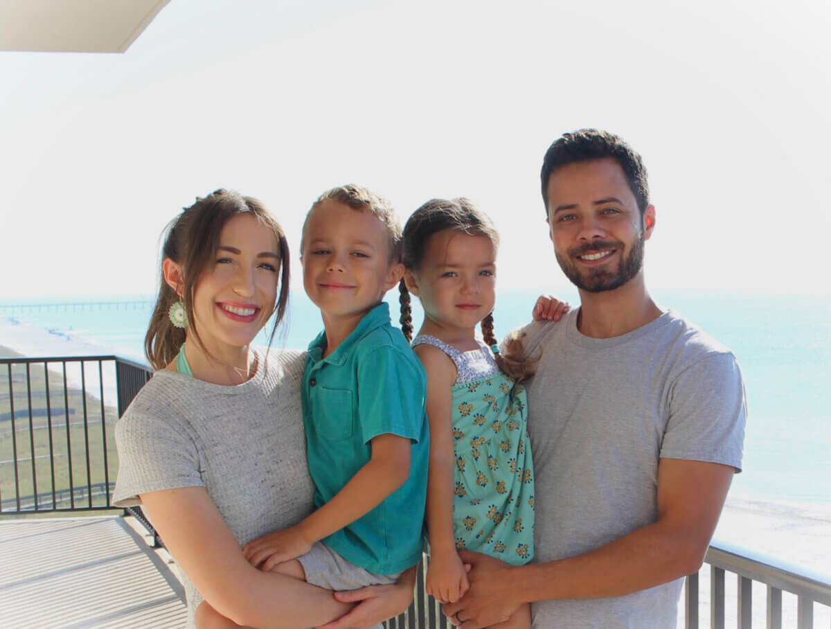 She’s Helping Put Books in the Hands of 500,000 Tennessee Kids - 5 A family of four stands on a balcony by the ocean, smiling.