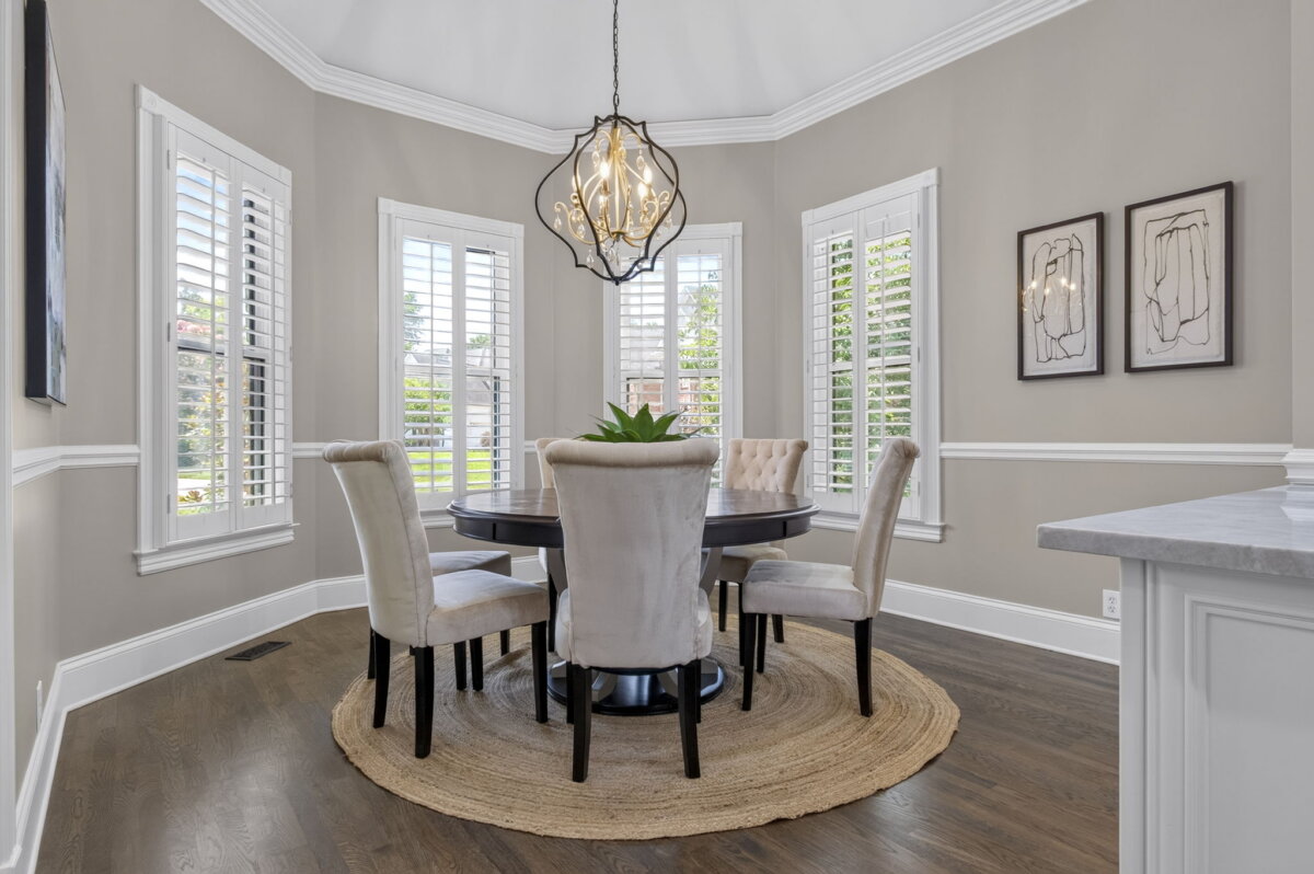 Just Listed! This Renovated Brentwood Home Has a Private Primary Wing, 4 Fireplaces & a Park-Like Backyard - 11 Bright dining area with a round table, four upholstered chairs, a jute rug, chandelier, and windows with white shuttersβperfect for enjoying views of the park-like backyard in this beautifully renovated Brentwood home.