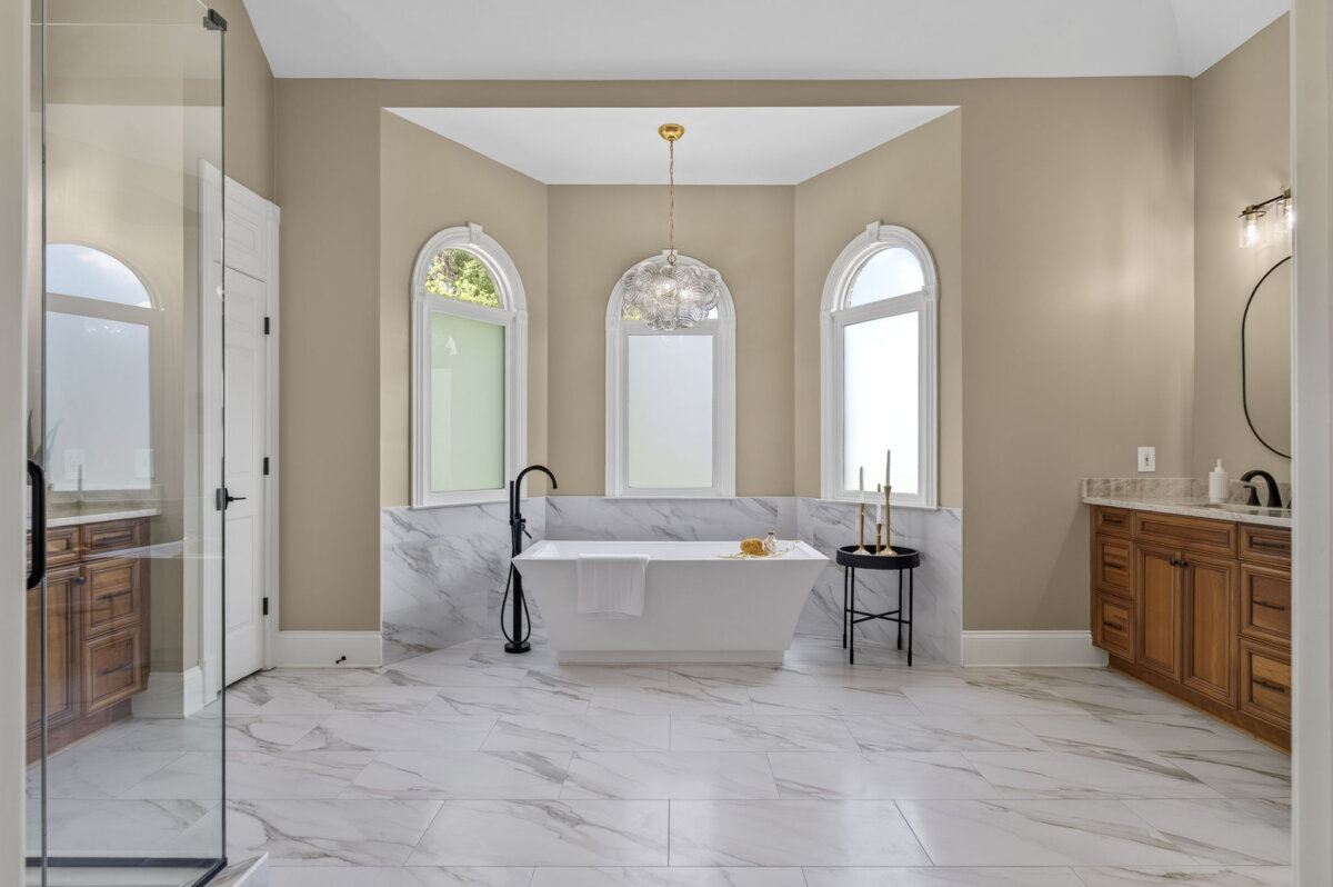 Just Listed! This Renovated Brentwood Home Has a Private Primary Wing, 4 Fireplaces & a Park-Like Backyard - 15 Renovated and spacious bathroom with marble floor, a freestanding tub beneath three arched windows, wooden vanities on both sides, and a glass shower enclosureβan elegant retreat within this beautiful Brentwood home.