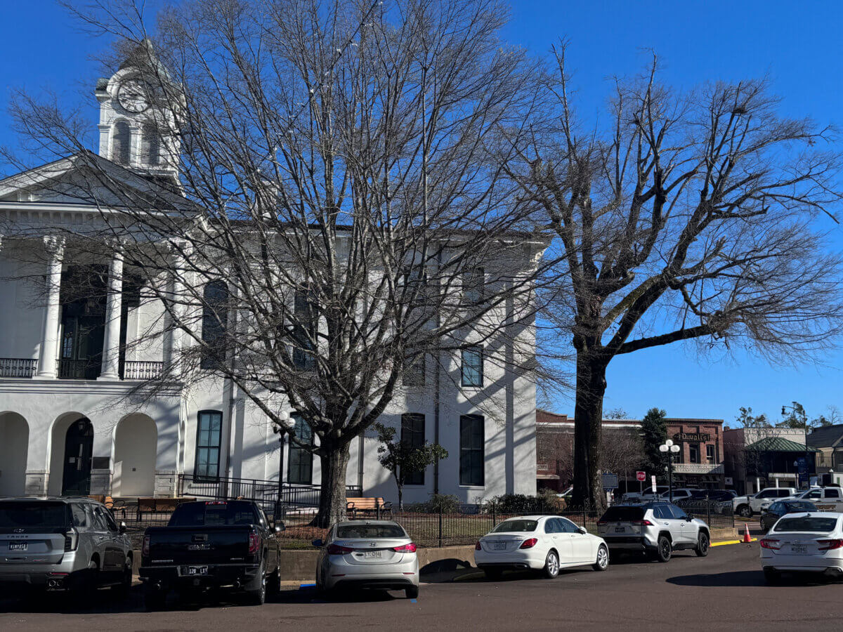 An Ode to Oxford: How to Eat Your Way Through This Delicious Small Town - 2 White courthouse with clock tower behind leafless trees; several parked cars in front; blue sky and nearby buildings visible, with popular Oxford restaurants just a short stroll away.