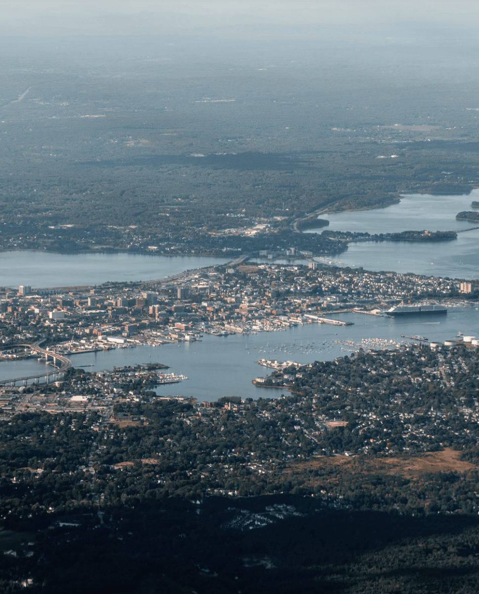 8 Easy Cool-Weather Escapes in the South & Beyond - 17 Aerial view of a South city surrounded by water, bridges, and dense greenery under a clear skyβan inviting destination for travel and cool-weather escapes.