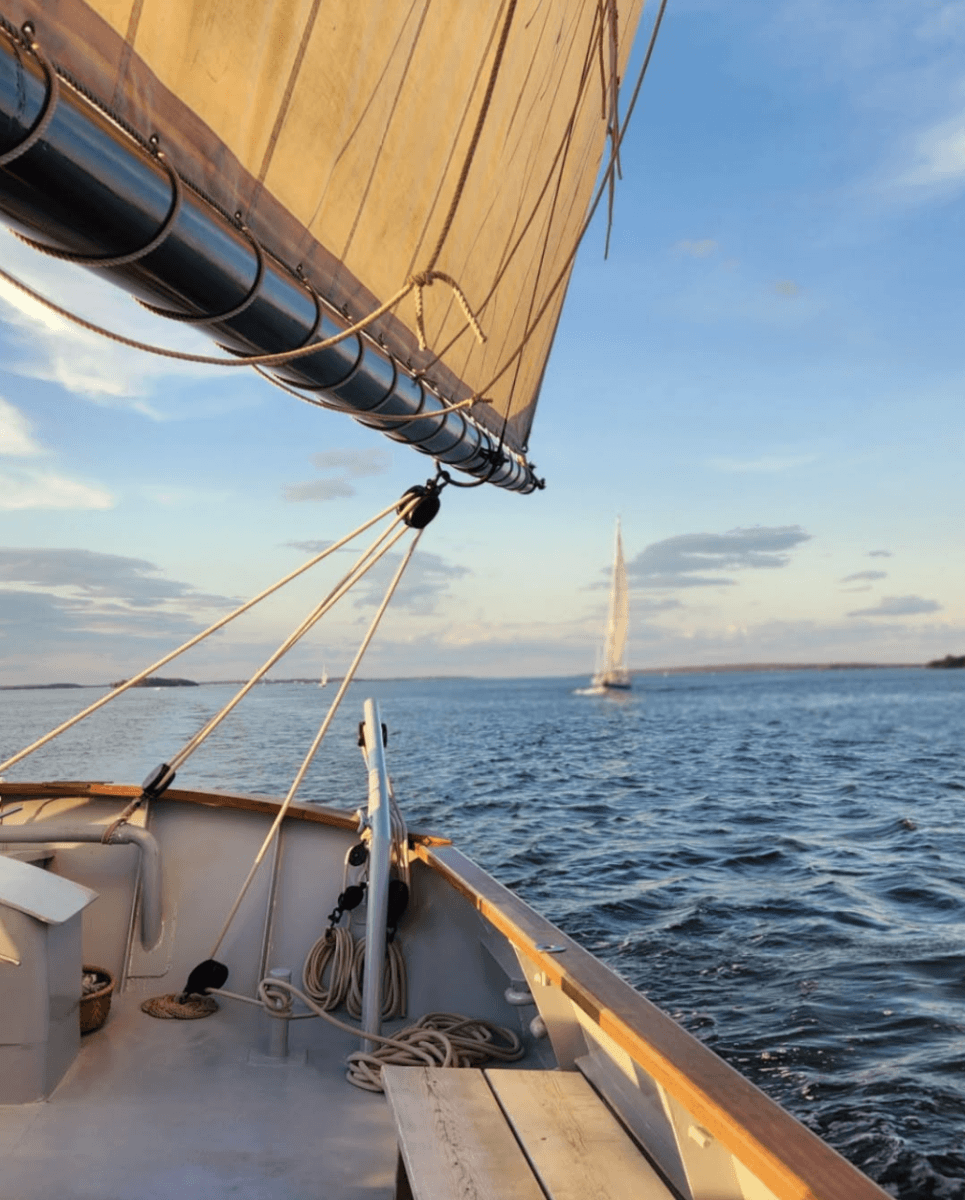 8 Easy Cool-Weather Escapes in the South & Beyond - 16 View from a sailboat on the water with another sailboat visible in the distance under a partly cloudy sky, perfect for those seeking cool-weather escapes.
