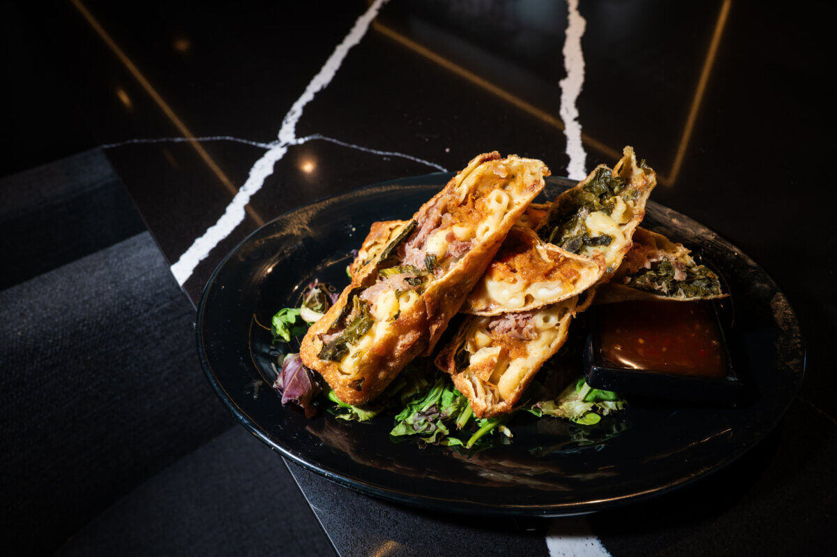 Egg rolls with macaroni and cheese, greens, and turkey.
