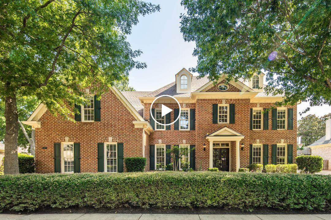 Charming two-story brick house at 1817 Liles, featuring black shutters, white trim, and a welcoming front porch. This beautiful home is partially shaded by large green trees and bordered by trimmed hedges along the sidewalk—an inviting example of Collierville real estate on Liles Ln in Collierville.