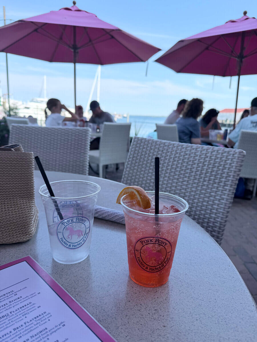 Midwest Weekend Getaway: My Mackinac Island Escape - 11 Outdoor table with two Pink Pony plastic cups, one with a red drink and lemon slice, one empty, menu in foreground.