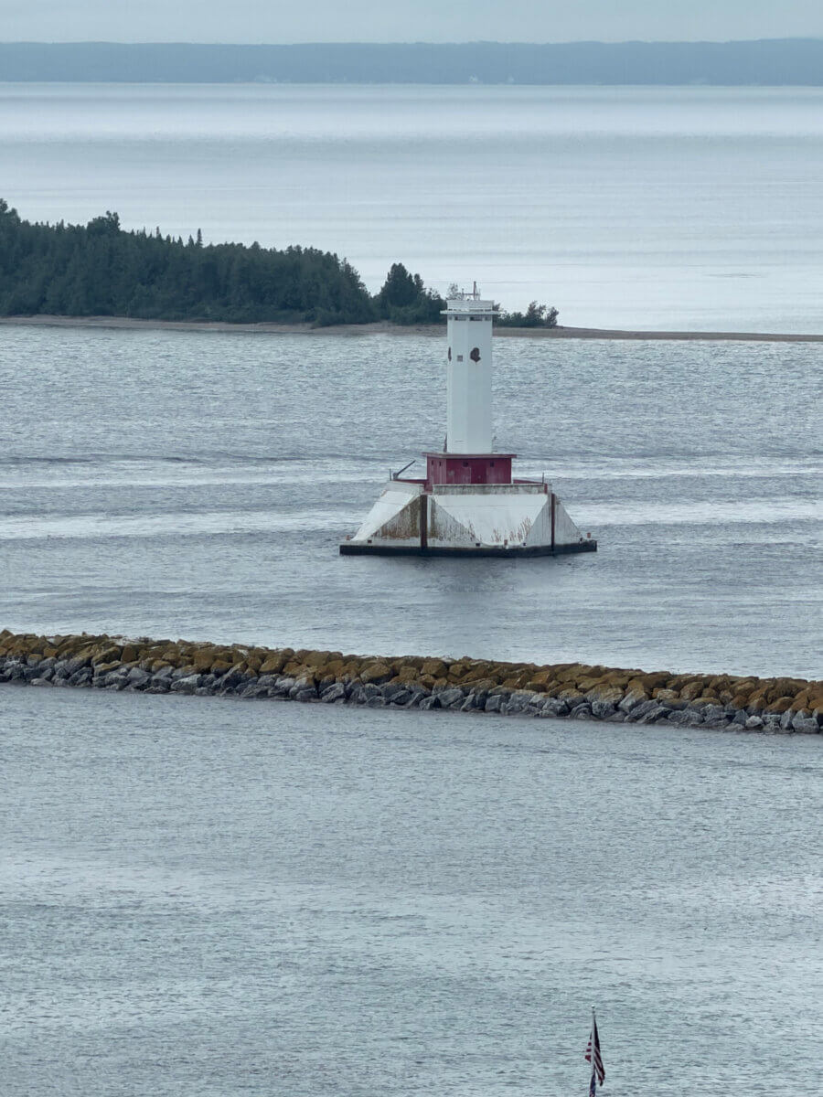 Midwest Weekend Getaway: My Mackinac Island Escape - 3 A white and red lighthouse stands on a concrete base in the water.