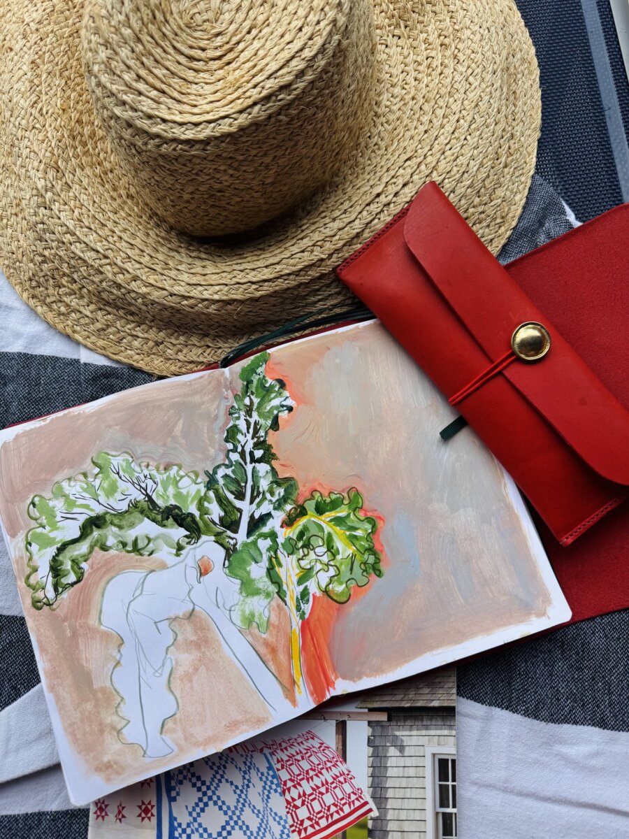 Step into the World of BHAM Artist Morgan Jones Johnston - 6 A straw hat, a red wallet, and an open sketchbook with a partially painted abstract plantβarranged on a striped fabric backgroundβevoke the artistic spirit of Morgan Jones Johnston.
