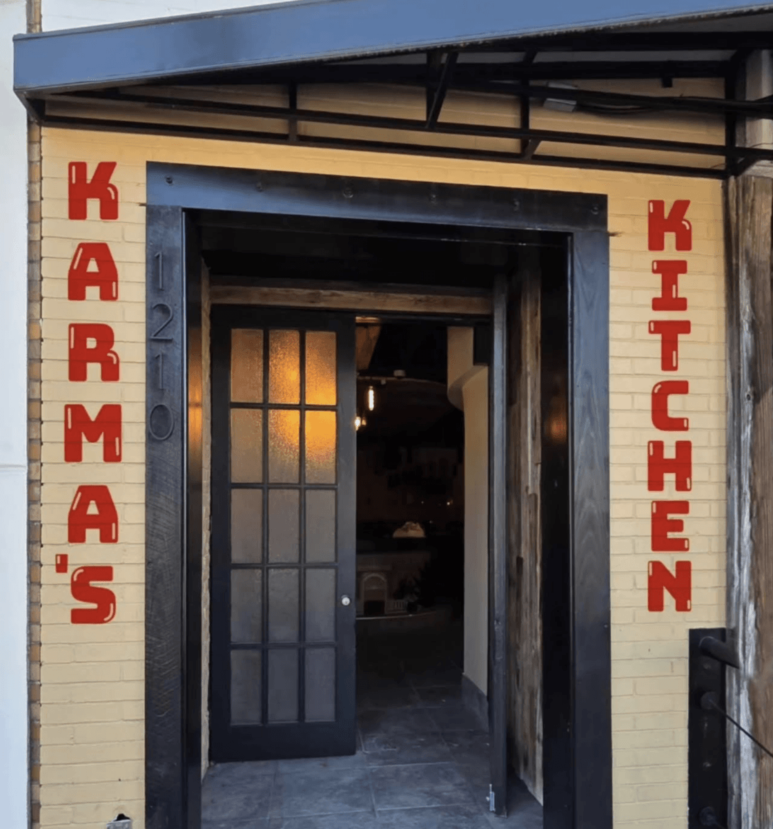 Restaurant entrance with “Karma’s Kitchen” in red vertical letters on each side of the doorway and the number 1210 on the left wall, introducing one of the exciting new restaurants redefining restaurant concepts among Birmingham restaurants.