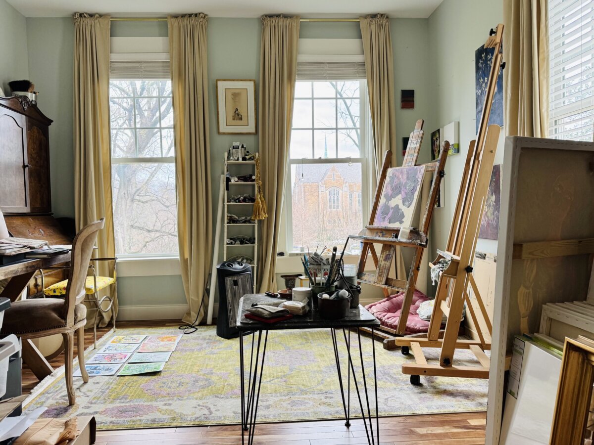 Step into the World of BHAM Artist Morgan Jones Johnston - 5 A bright art studio, designed by Morgan Jones Johnston, features two easels, paintings, and art supplies on a table.