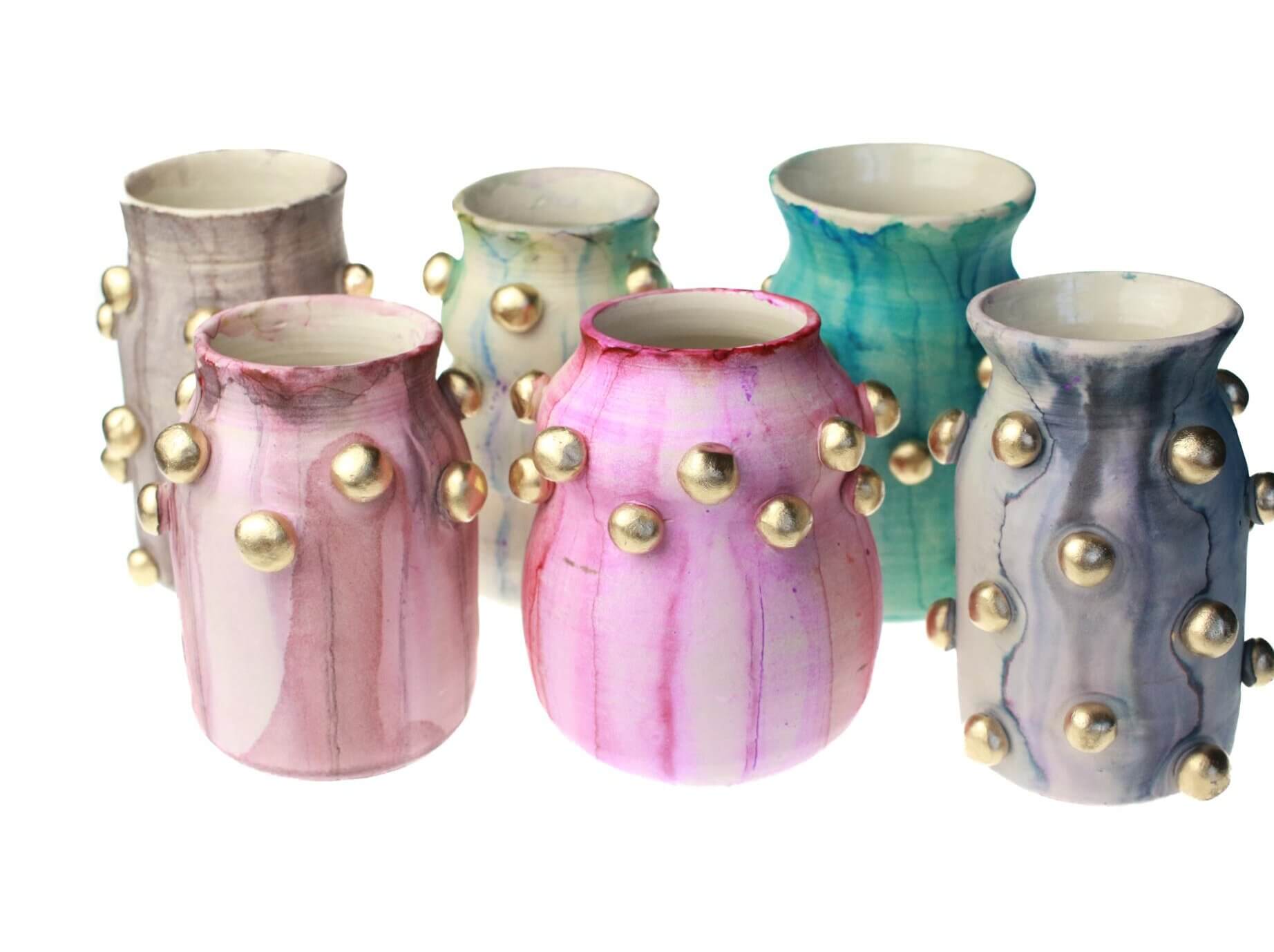 She Brings Art, Vintage Finds & Creativity to Memphis - 7 Six ceramic vases with metallic gold round accents, featuring pink, blue, purple, and teal marbled patterns, are arranged on a white background.