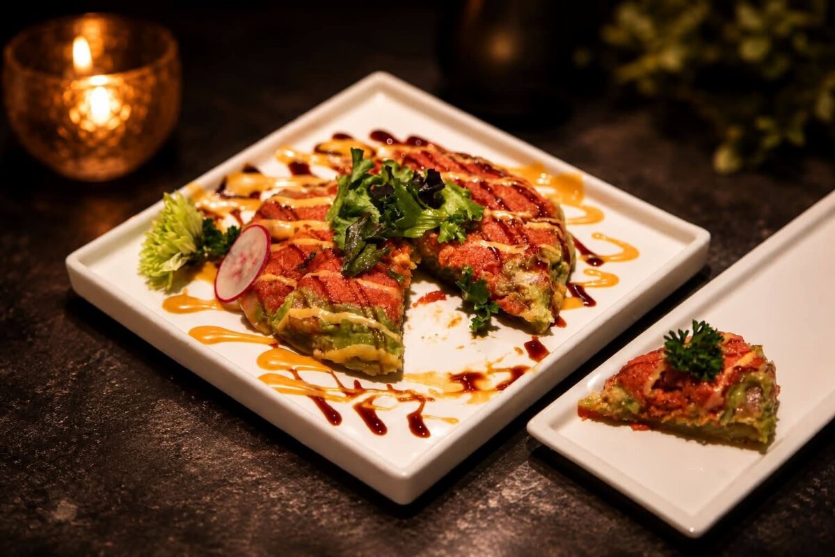 3 New Louisville Restaurants to Try (Plus 3 New Menus!) - 4 A sliced gourmet dish with greens, sauces, and a radish garnish is served on a square plate; a smaller slice is placed on a rectangular plate beside it—an artful presentation often seen on restaurant menus at new Louisville restaurants.