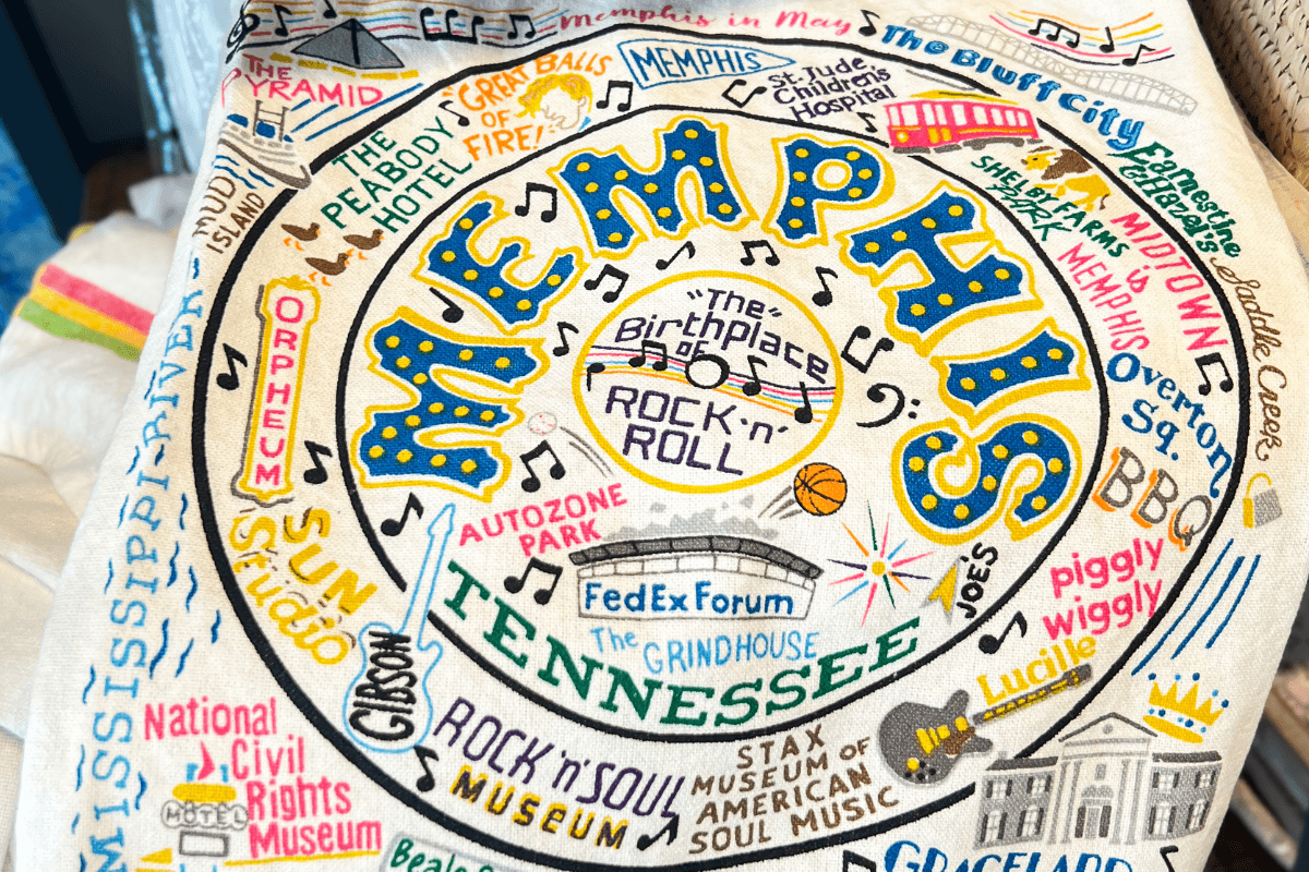 Colorful cloth artwork featuring Memphis, Tennessee, with illustrated landmarks, music notes, and phrases like “The Birthplace of Rock ‘n’ Roll” and “The Bluff City” in bright, bold lettering.