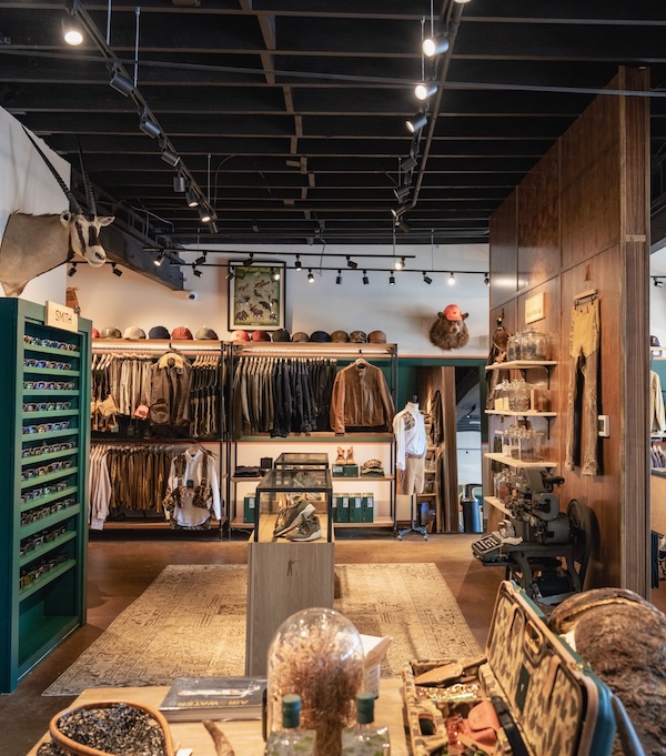 9 New Nashville Retail Spots to Explore - 6 A Nashville retail clothing store interior displays jackets, hats, and accessories on shelves and racks, with taxidermy animal heads and various decor items visible throughout the space.