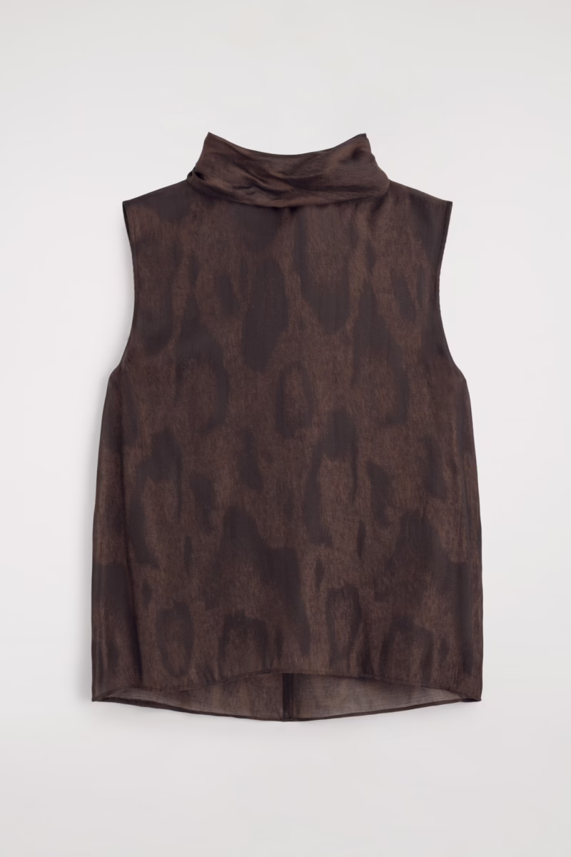 Sleeveless, high-neck, brown top with a subtle, dark leopard print pattern—an effortlessly chic piece embracing fall trends—shown laid flat against a white background. 