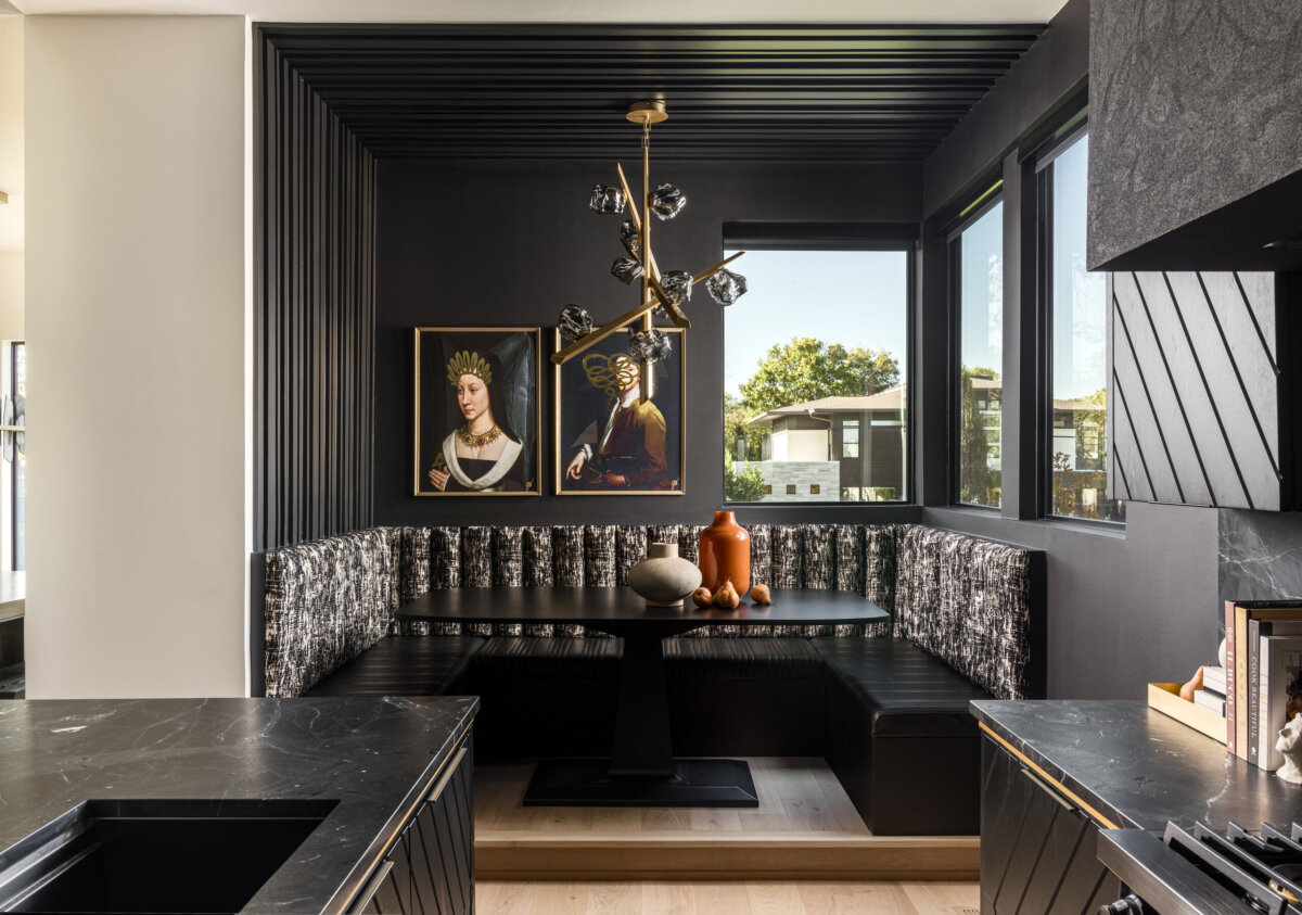 There's a Graffiti-Covered Bust in This Nashville Home, and It Works - 10 Striking modern black breakfast nook with patterned bench seating, two royal-themed portraits reminiscent of a modern art gallery, a contemporary chandelier, large windows, and a small black table decorated with vases and a bowl—an inspired touch for any Nashville home.