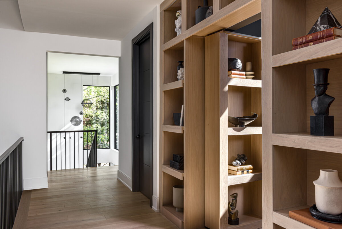 There's a Graffiti-Covered Bust in This Nashville Home, and It Works - 12 A hallway with bookshelves that boast fun vignettes.
